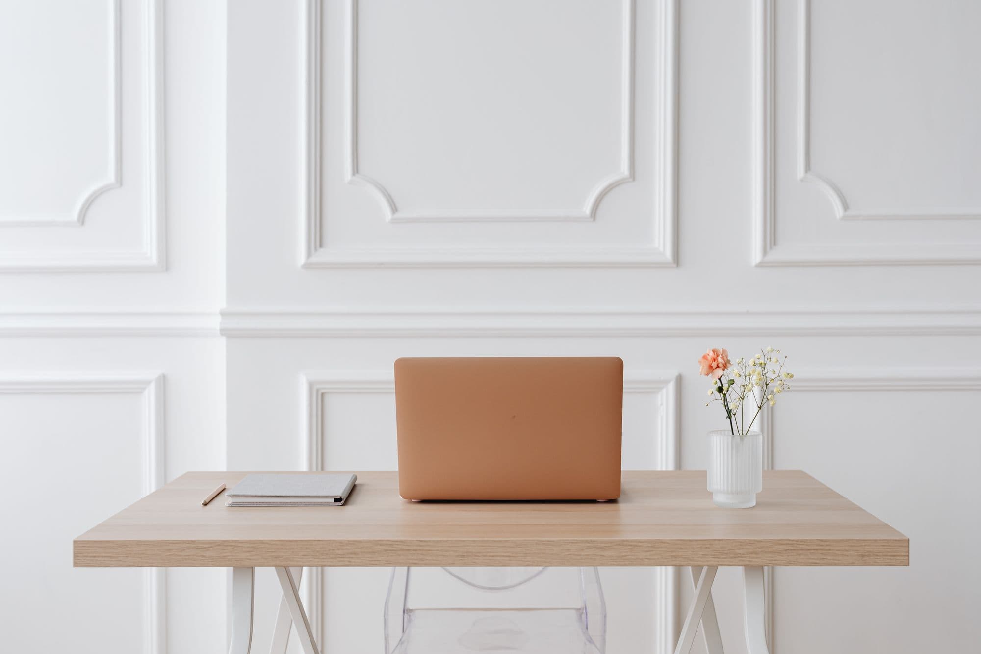 A laptop open on a copper-lit desk
